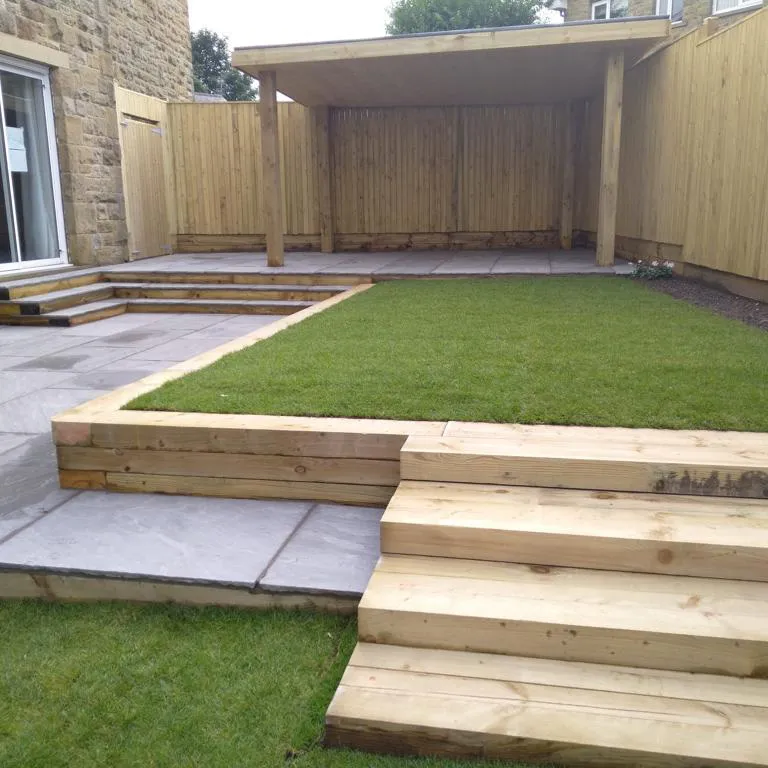 A backyard with grass and wooden steps.