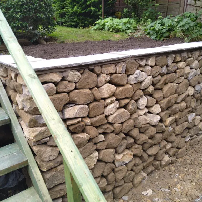 A stone wall with steps leading up to it.