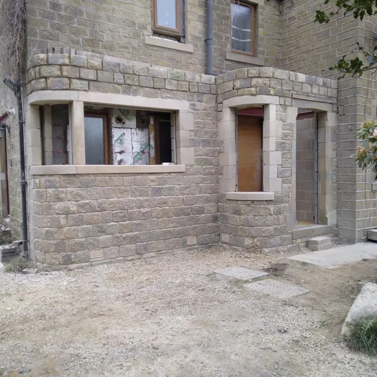 A brick building with two windows and a door.